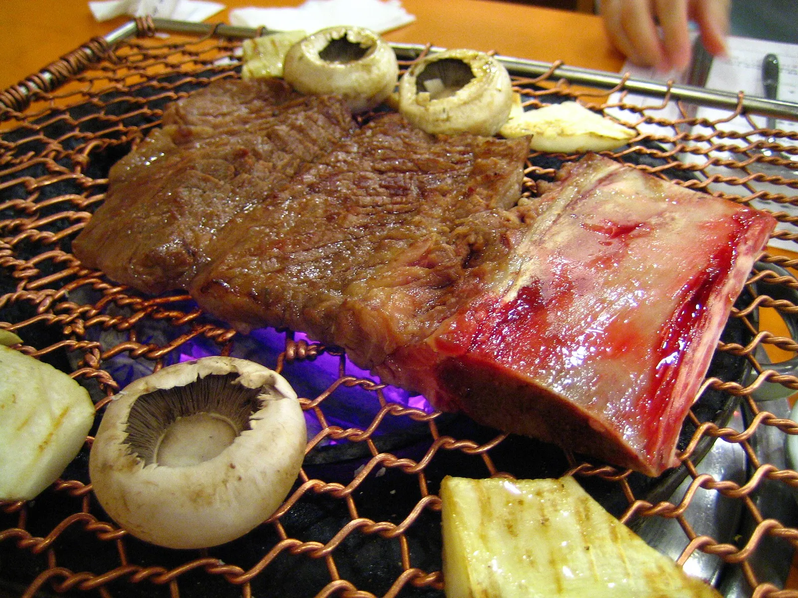 Galbi, marinated beef short ribs grilling over charcoal