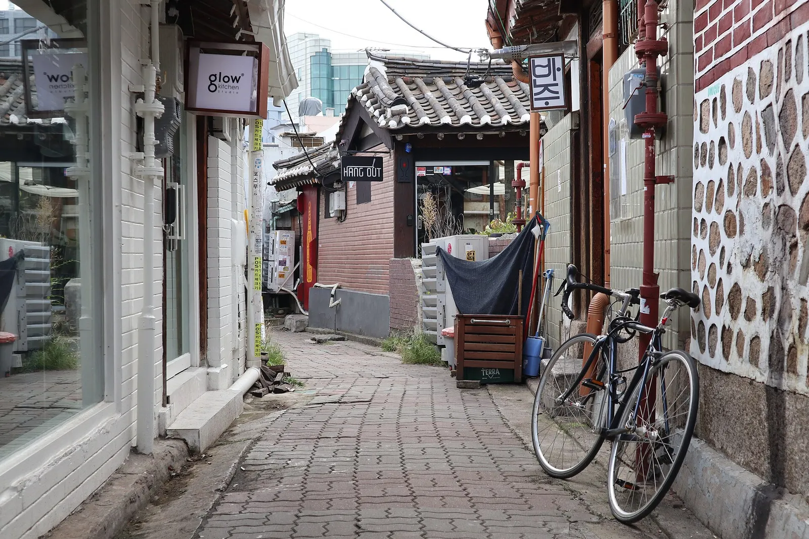 An Ikseon-dong alley, a shop sign hung above a hanok gate and a bicycle propped against the wall