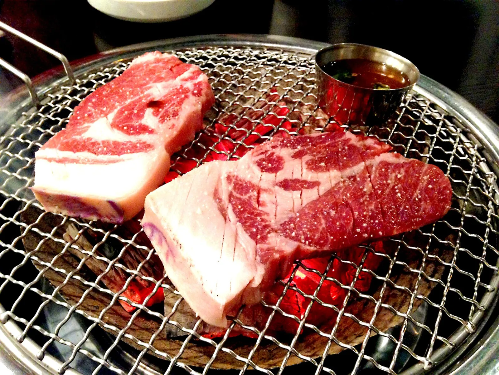 焼肉店の鉄板の上で焼かれている豚バラ肉