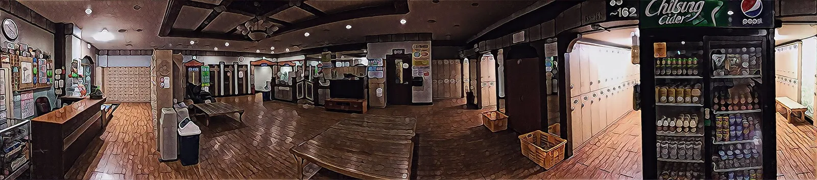 チムジルバンの共用休憩スペースを横長に撮った写真、板の間に低い台とロッカー、飲み物の冷蔵庫が見える