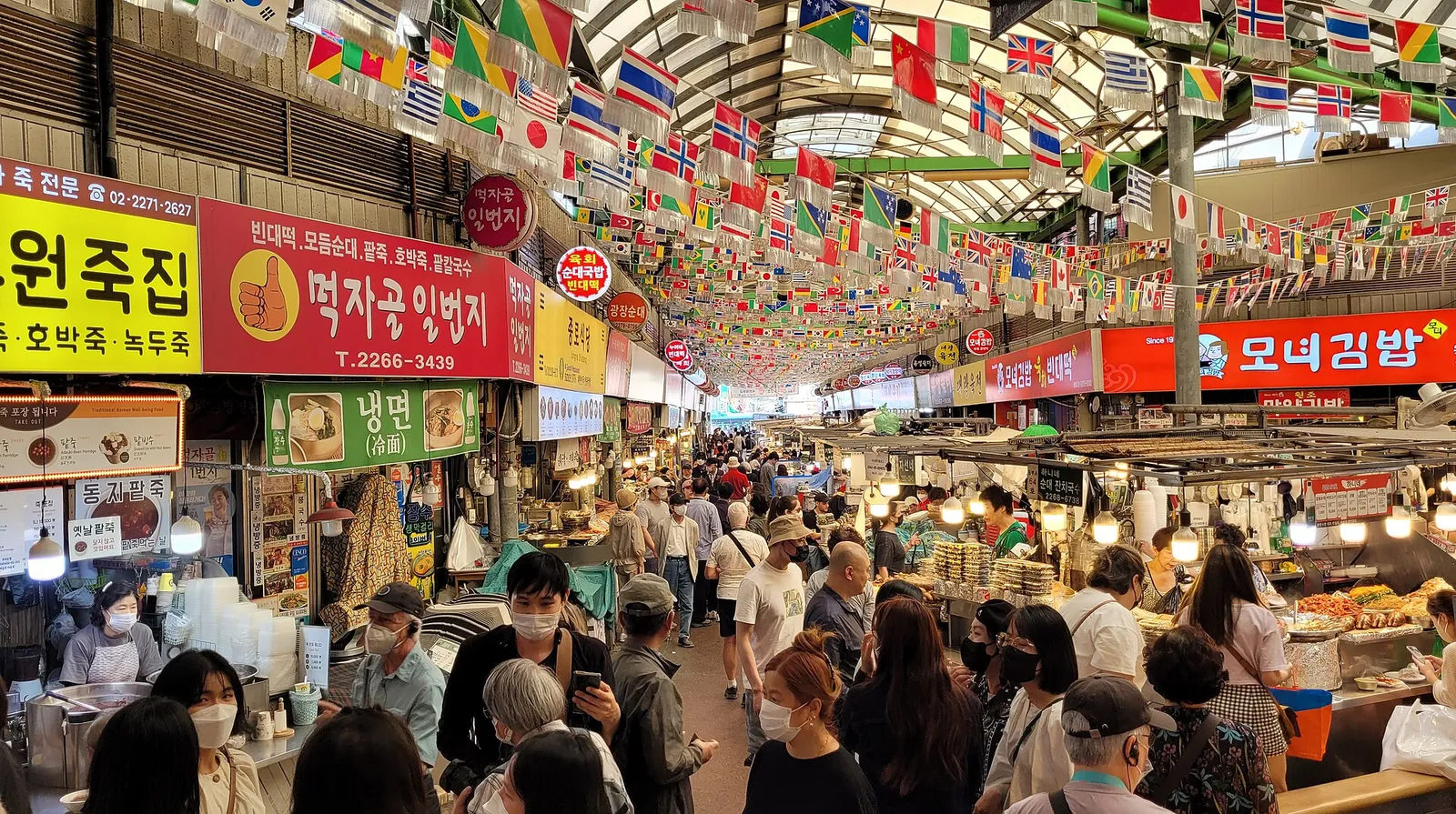 Crowded food stalls in the covered alleys of Gwangjang Market
