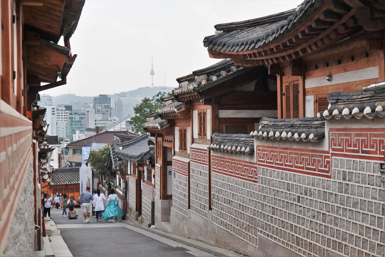 Tiled hanok roofs in Bukchon with the city behind