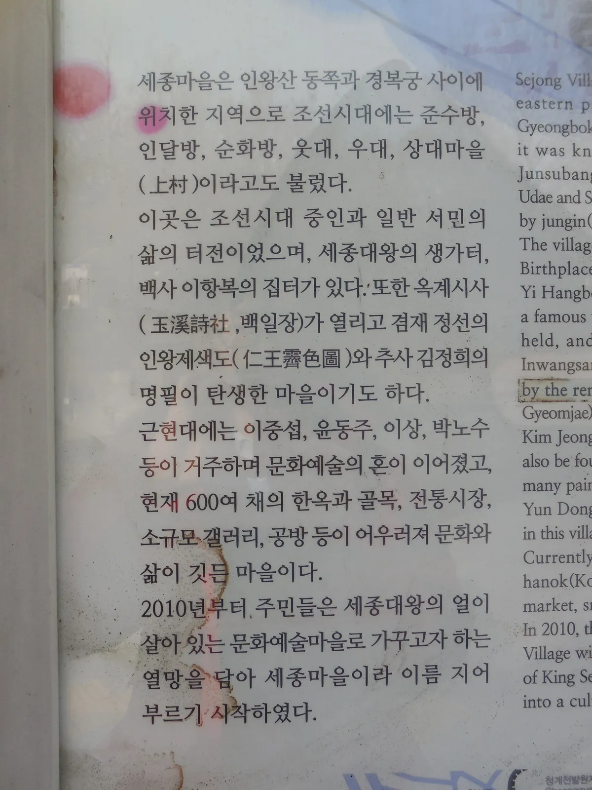 A Sejong Village information board, the neighbourhood's old name and history written in Korean and English