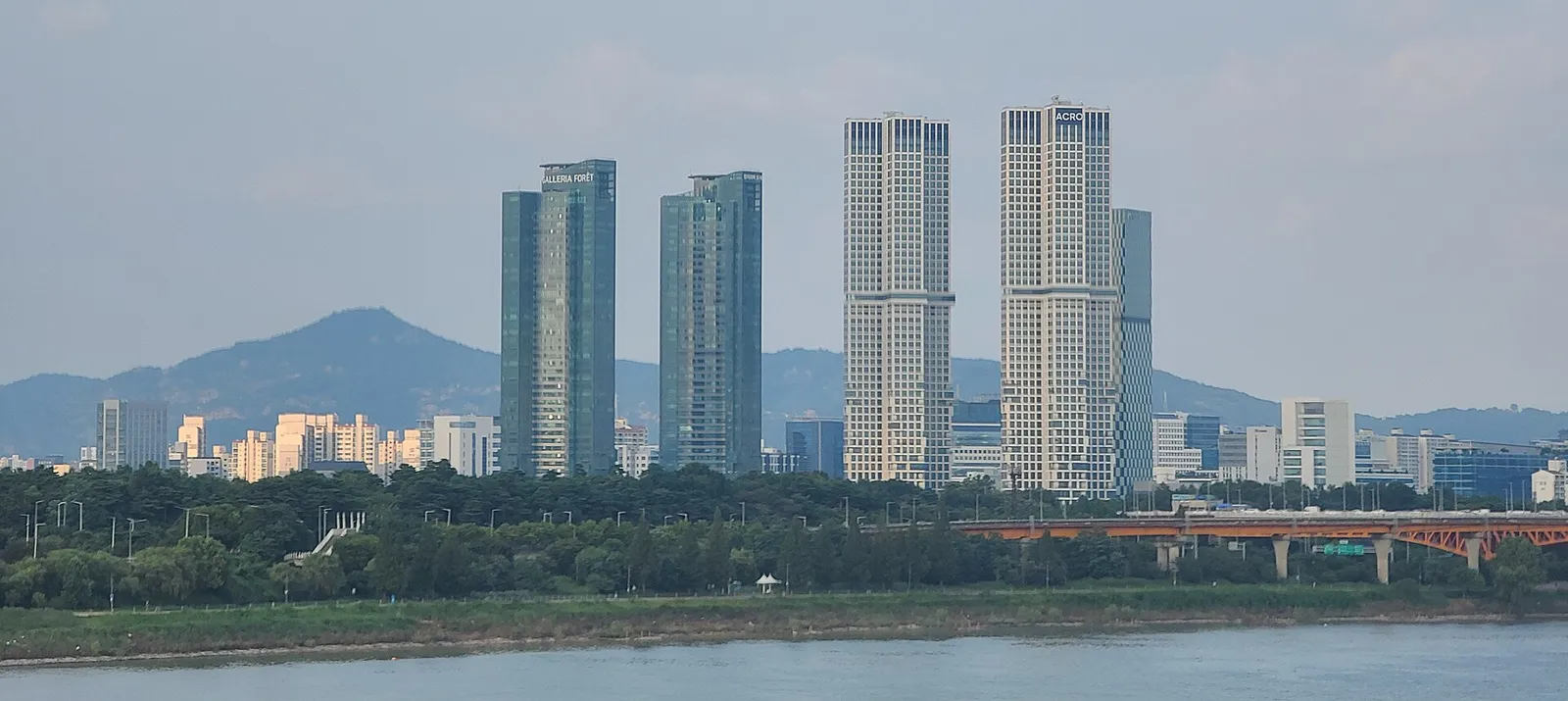 Seoul Forest seen from across the Han River, with a line of high-rise residential towers behind it