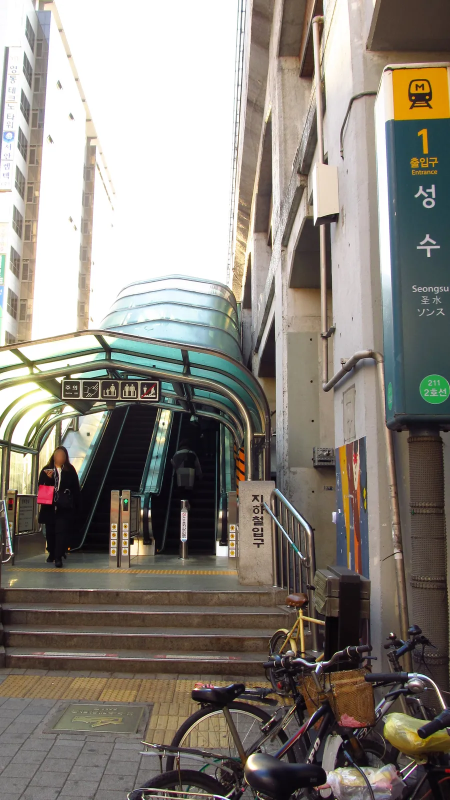 The station name plate on the pillar at Seongsu Station exit 1, marked Line 2, number 211