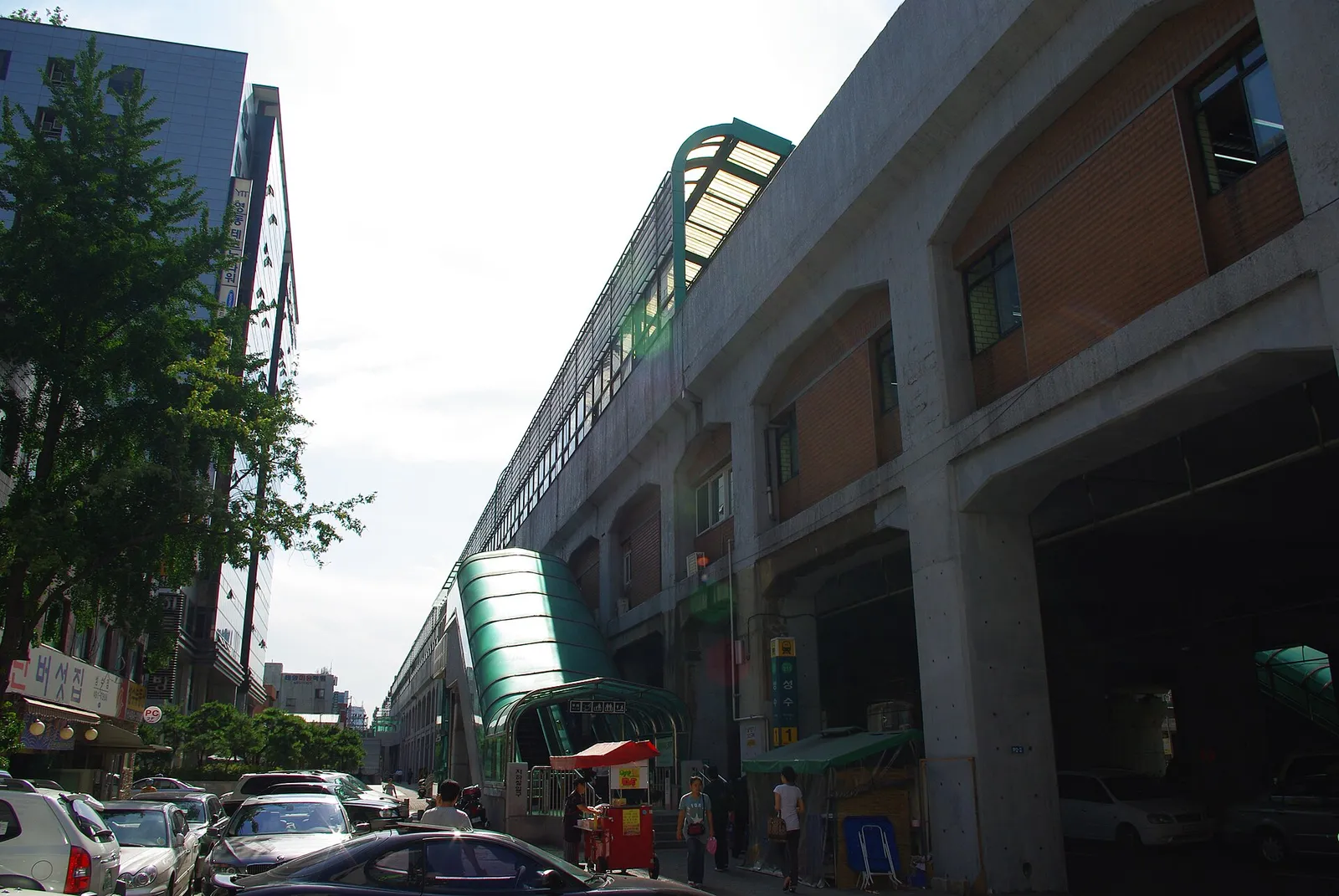 The street and shopfronts running underneath the elevated structure of Seongsu Station