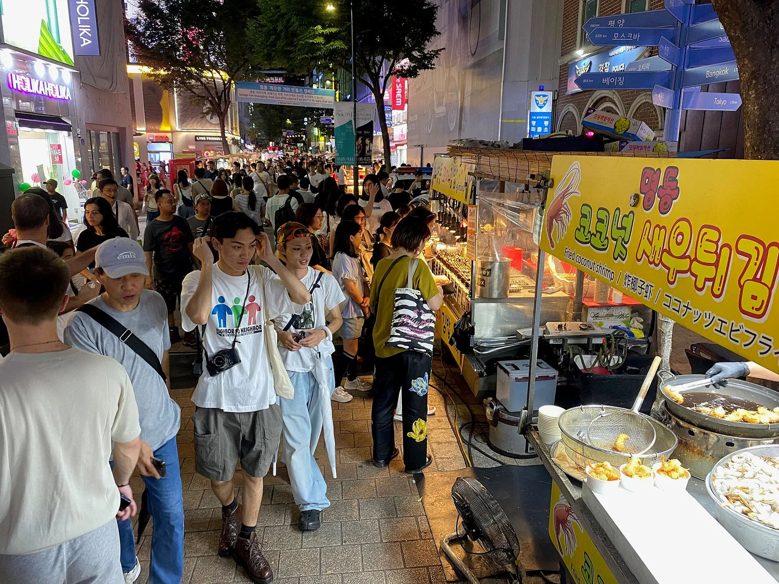 Crowds and street food stalls on Myeongdong shopping street at night