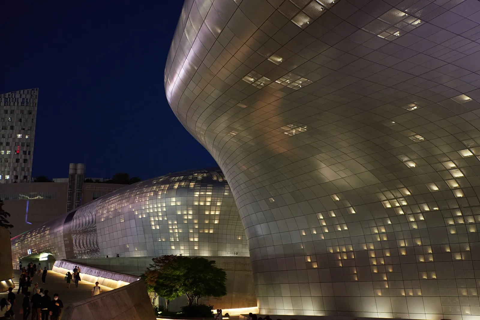 The curved facade of Dongdaemun Design Plaza lit up at night