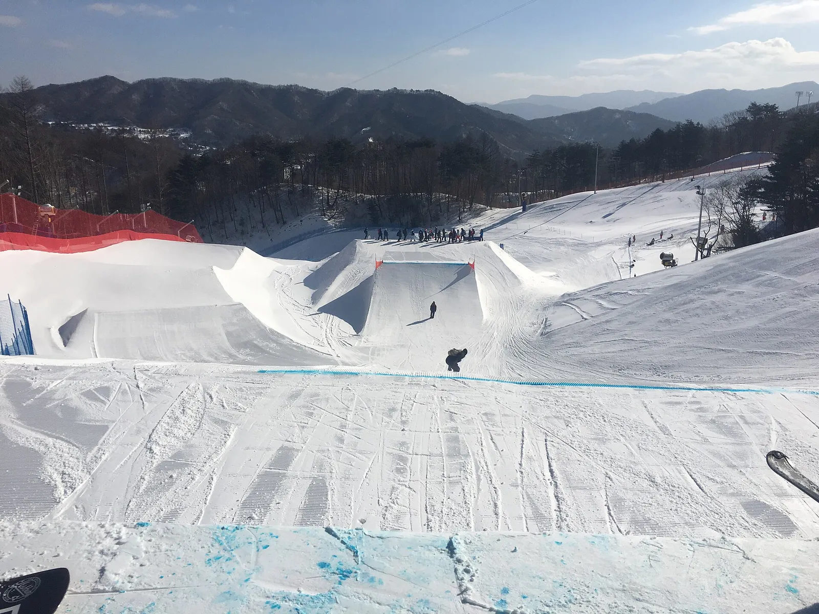 フェニックスパークのスノーパーク、ハーフパイプとジャンプ台、滑り降りてくるスノーボーダーが1人